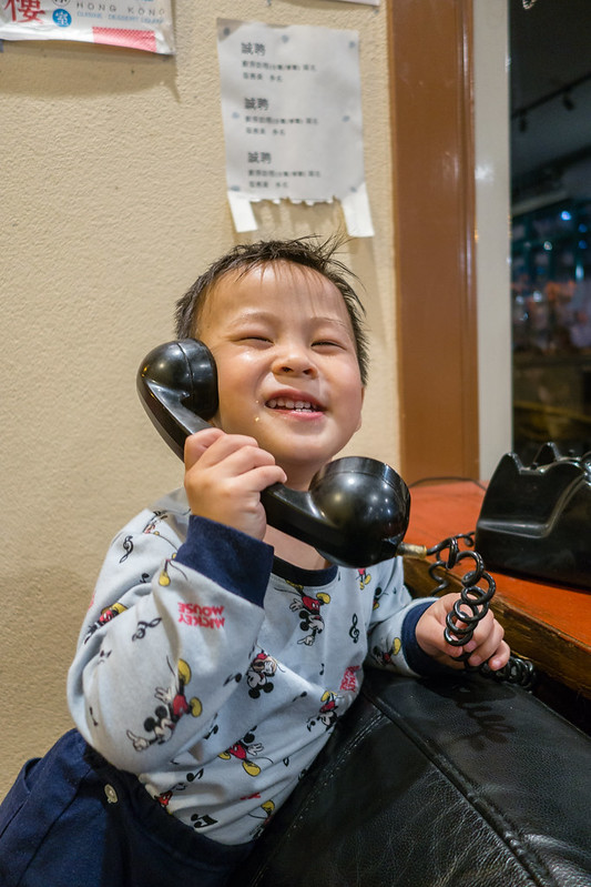 Cute baby having an engaging conversation on a rotary phone